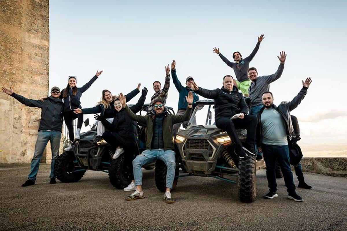 Un grupo de personas posando para una foto con sus vehículos todo terreno.