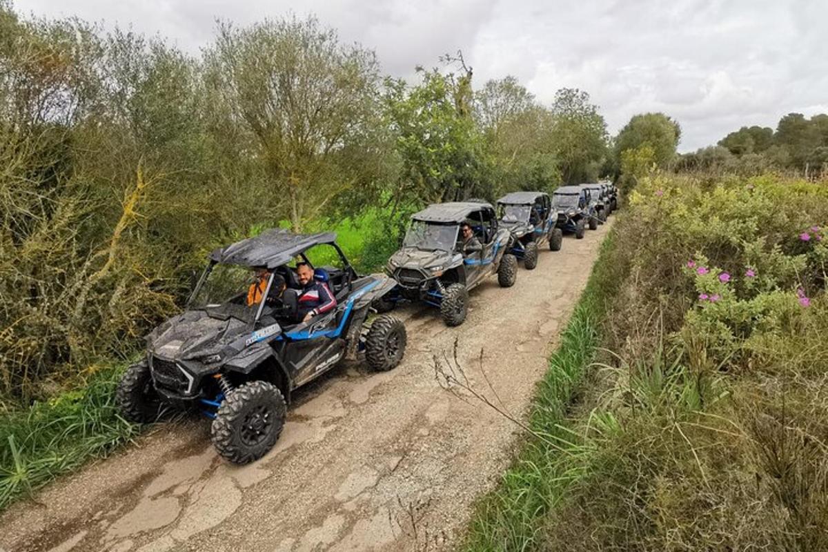 Una fila de vehículos todo terreno circulando por un camino de tierra