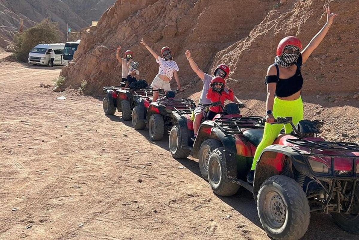 un gruppo di persone in sella a quad nel deserto