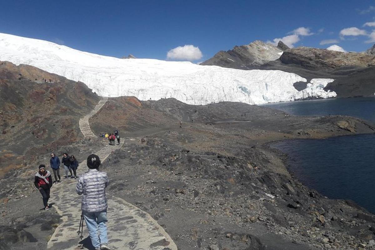 Un grupo de personas caminando por una montaña con un glaciar.