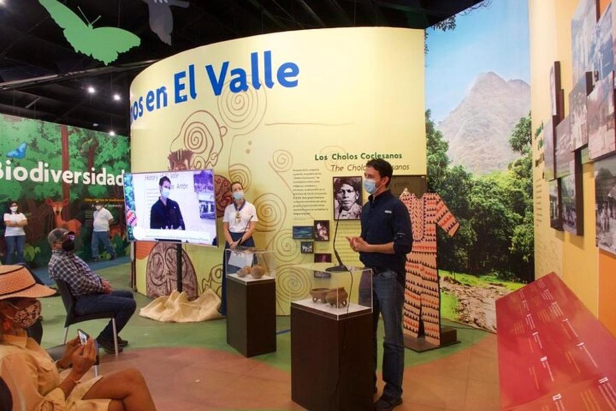 Un hombre parado frente a un stand en una exposición.