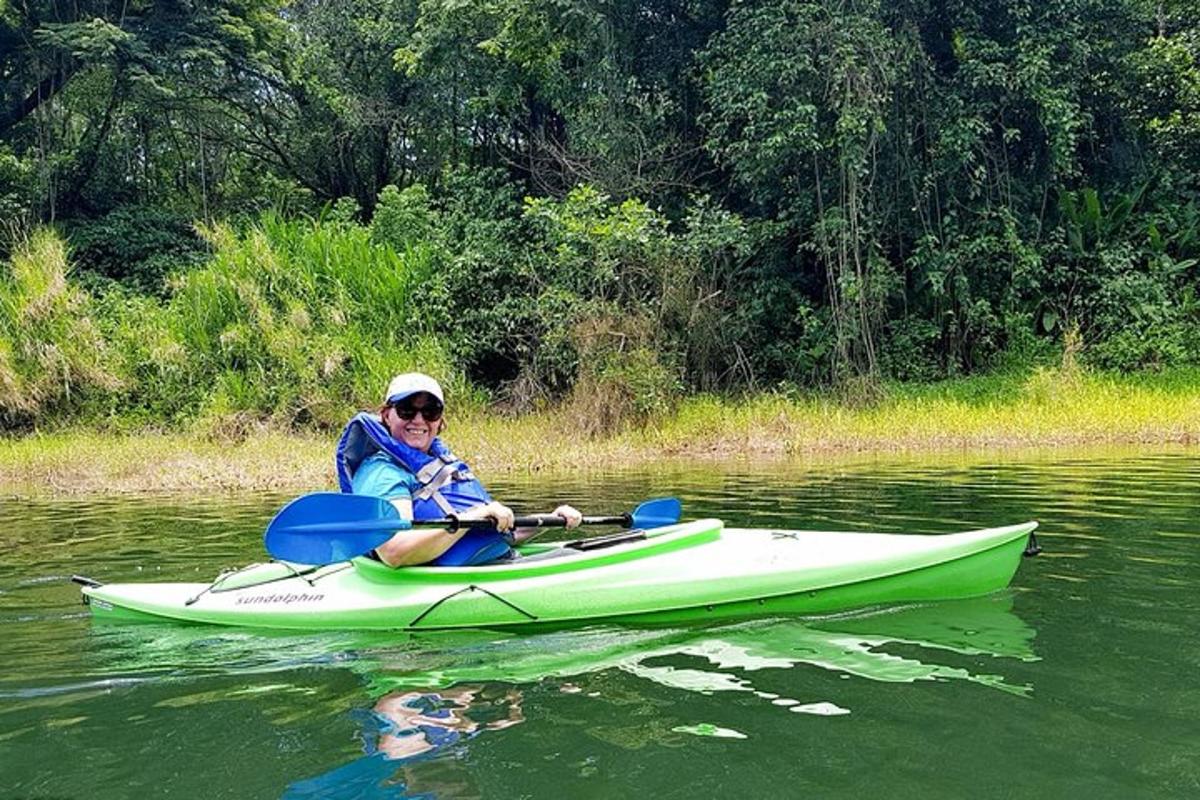 a person is sitting on a green kayak in the water