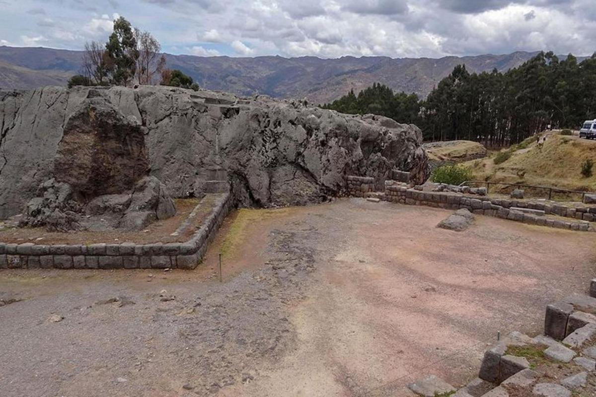 un gran mur de pedra davant d'una muntanya
