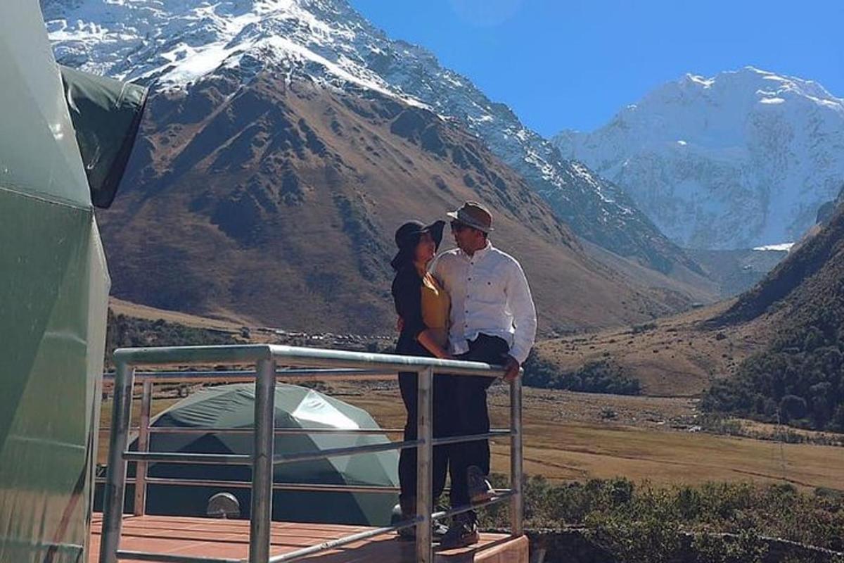 a man and a woman standing on a railing next to a tent