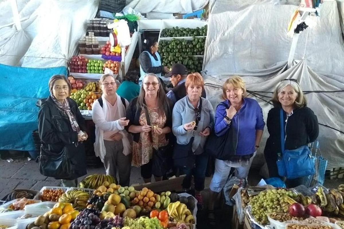 група жена стоји испред тезге са воћем