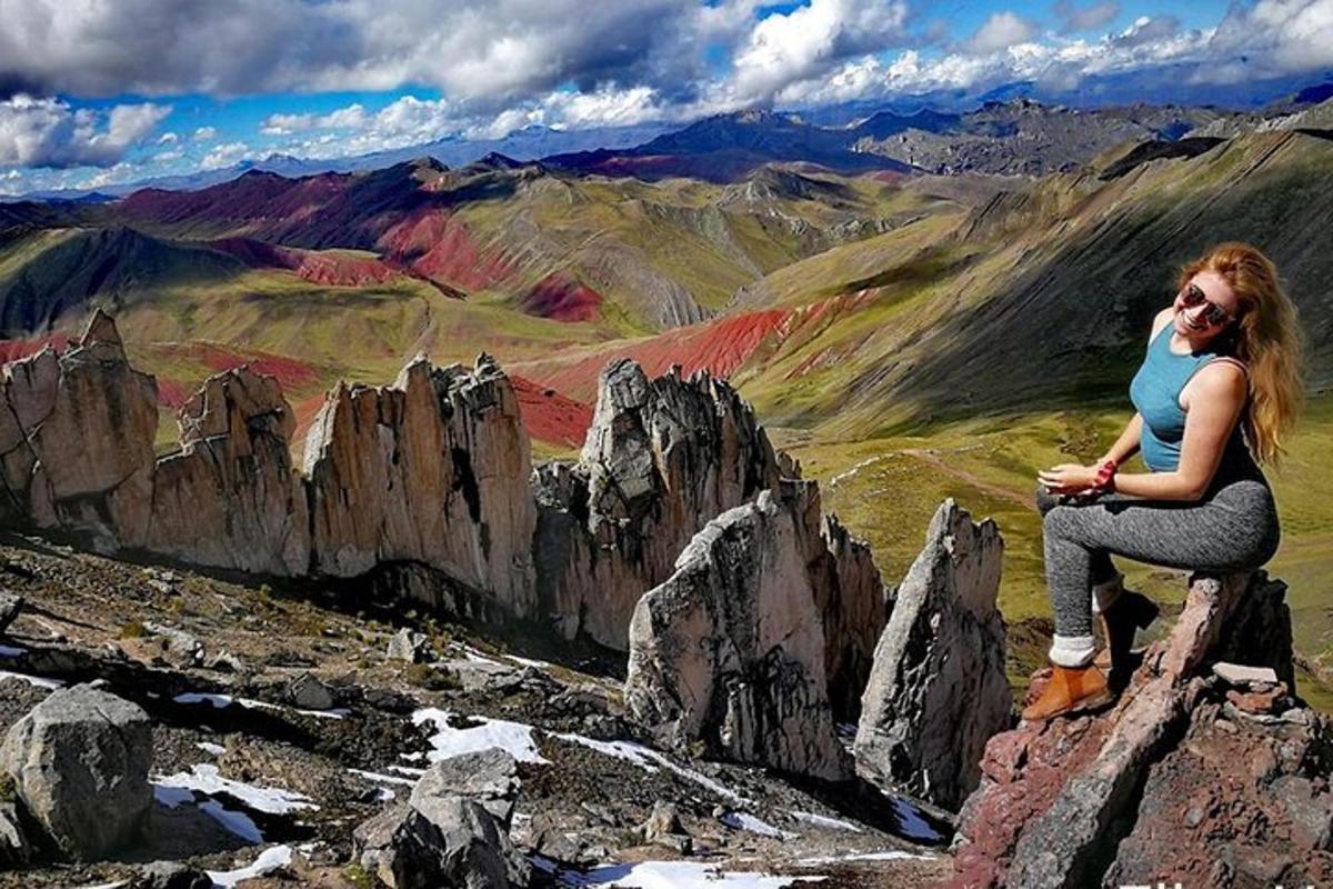 a woman sitting on a rock on a mountain