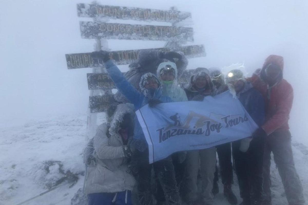 um grupo de pessoas segurando uma placa na neve