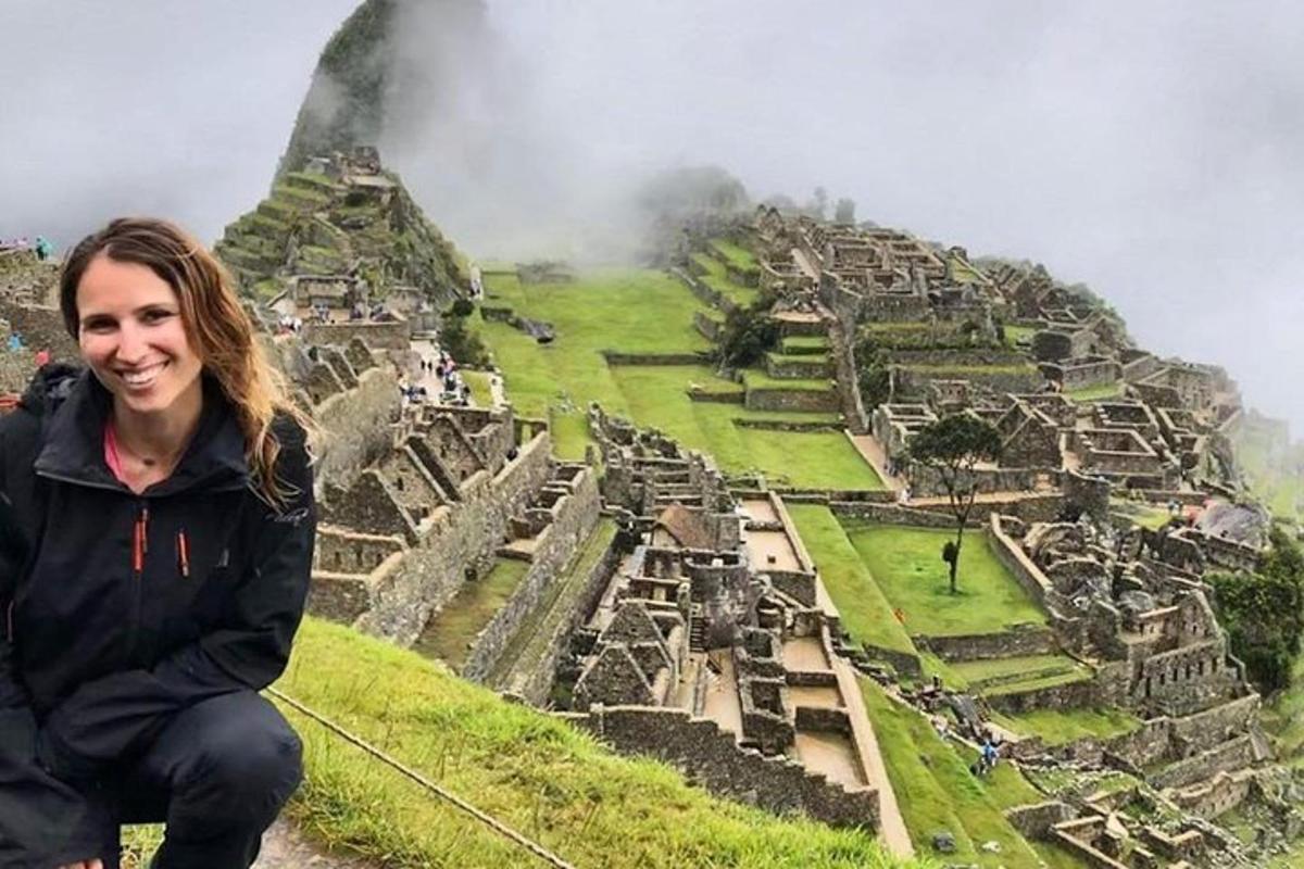 žena sedící na vrcholu kopce s výhledem na ruiny