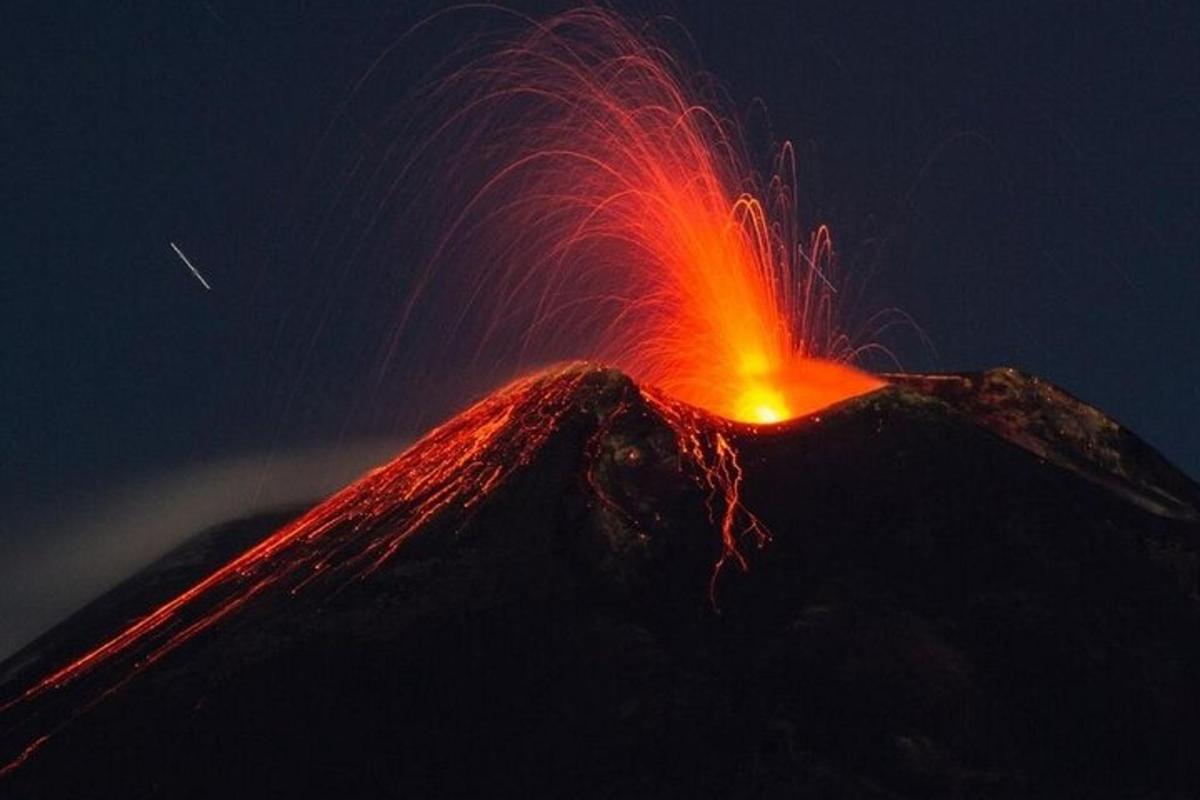 Un volcán en erupción con lava roja en la cima.
