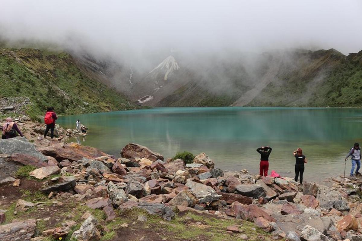 un grup de persones dempeus sobre roques prop d'un llac