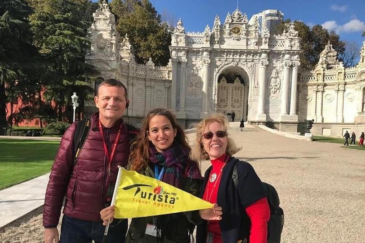 Ένας άνδρας και δύο γυναίκες στέκονται μπροστά σε ένα κτίριο