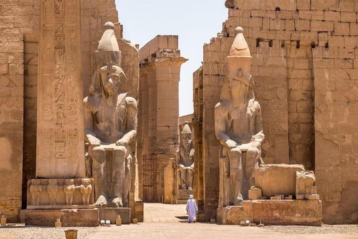 un uomo in piedi davanti a due grandi statue