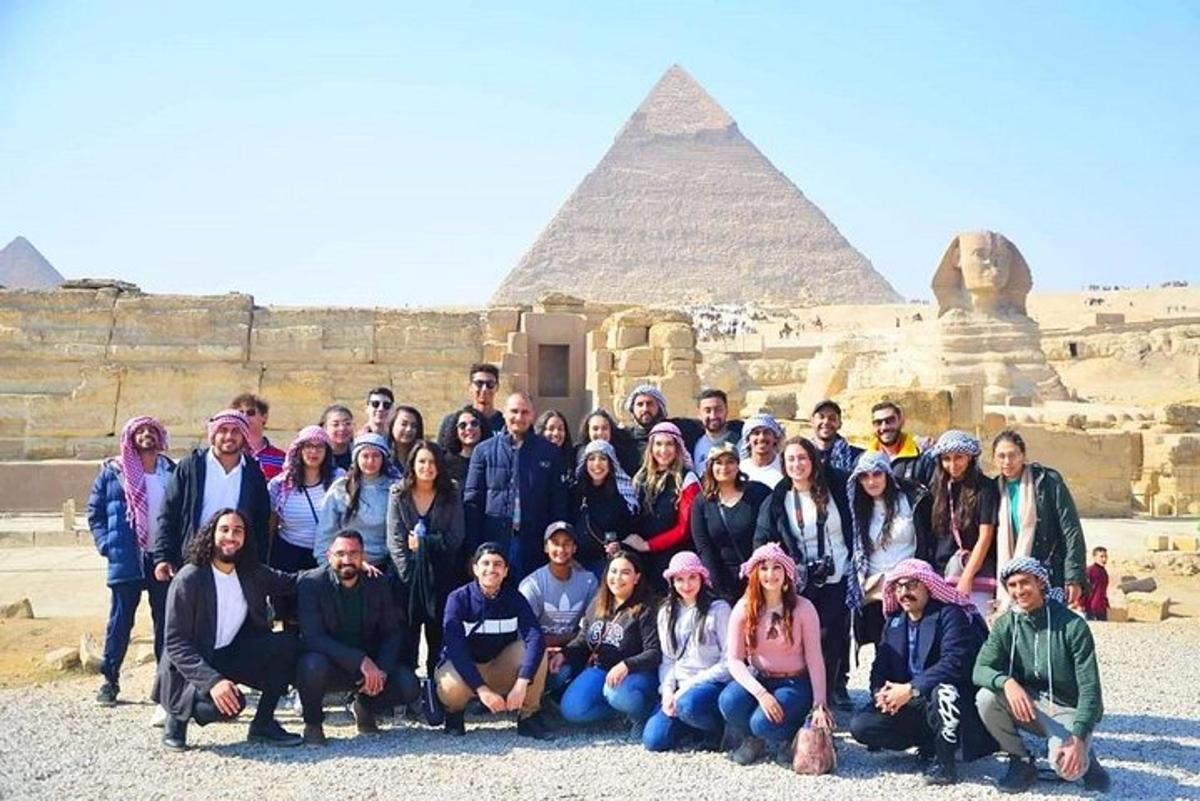 Skupina lidí pózujících před pyramidami