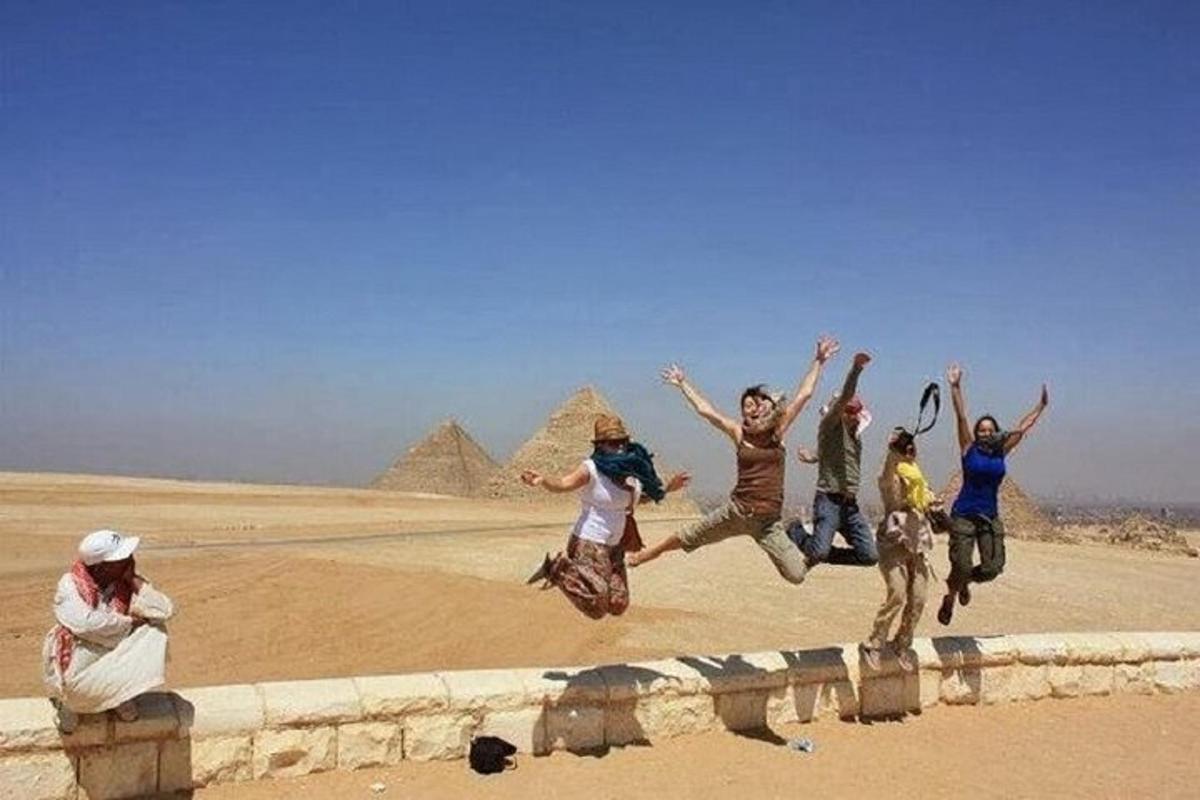 eine Gruppe von Menschen, die vor den Pyramiden springen