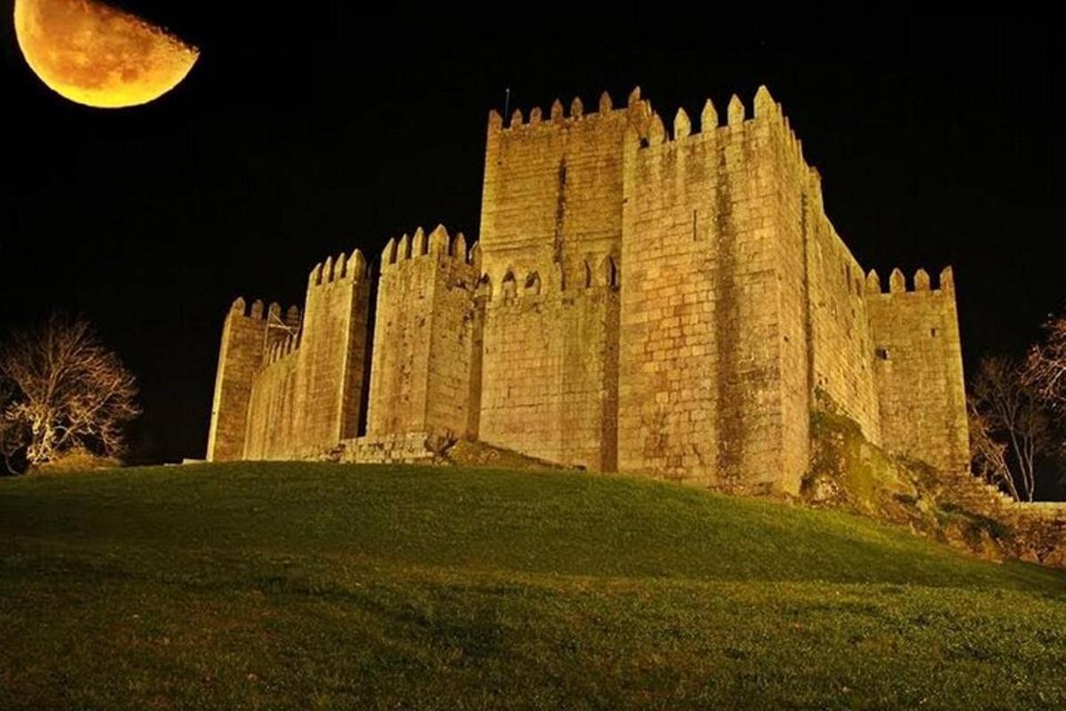 a large castle on a hill at night with a moon