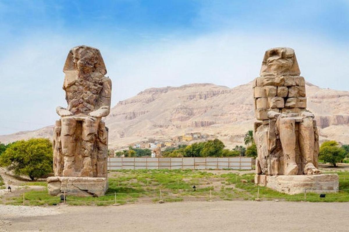 deux grandes statues de pierre devant une montagne