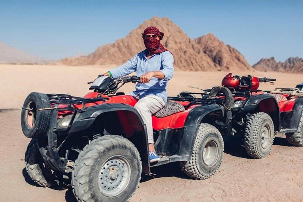 a man sitting on a four wheeler in the desert