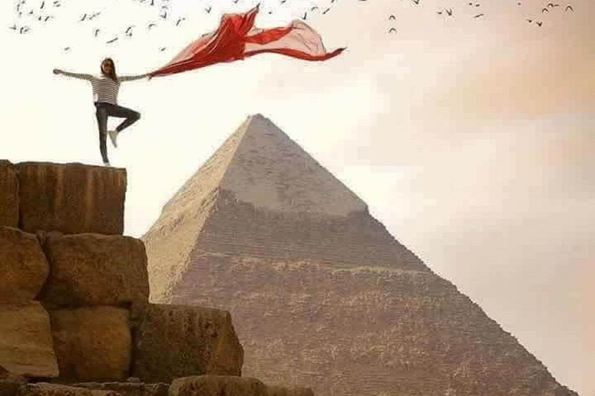 žena stojící na vrcholu pyramid