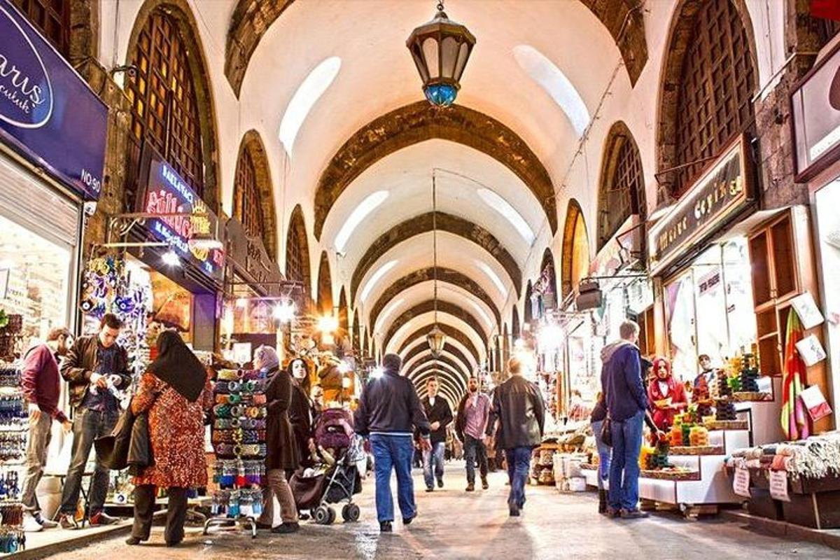 un grup de persones caminant per un mercat cobert