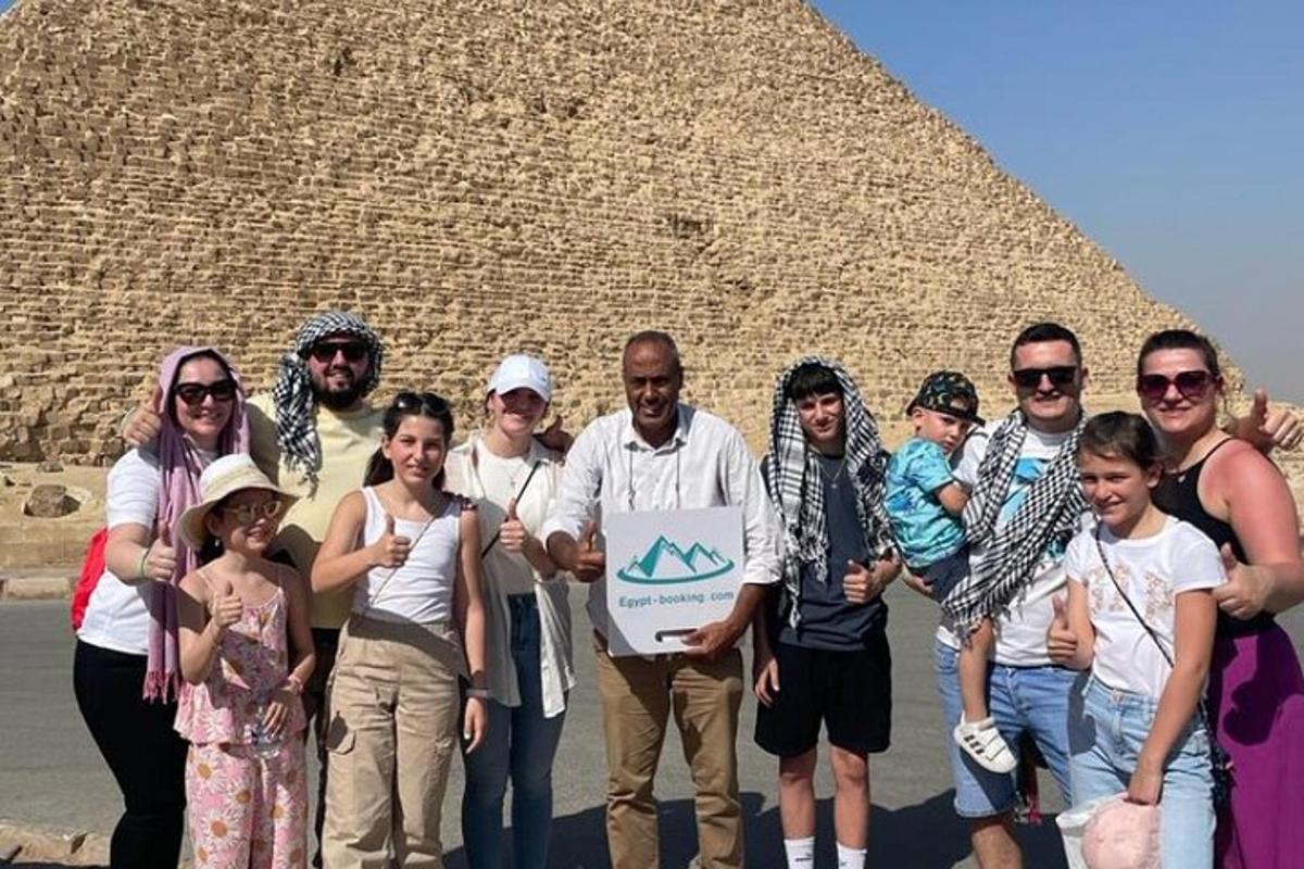 skupina lidí stojící před pyramidou
