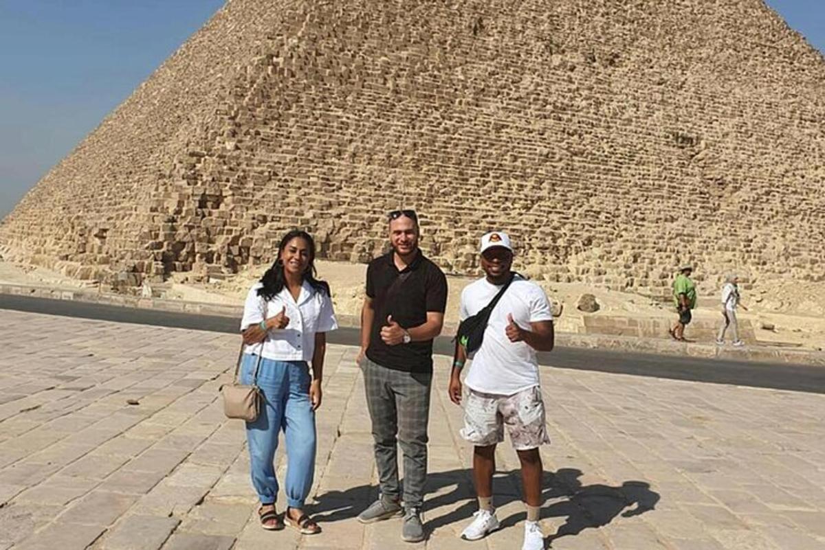 tři lidé stojící před pyramidou
