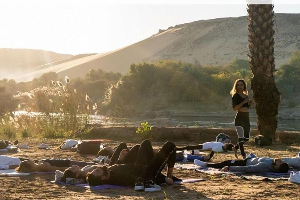 una donna in piedi accanto a un gruppo di persone che fanno yoga