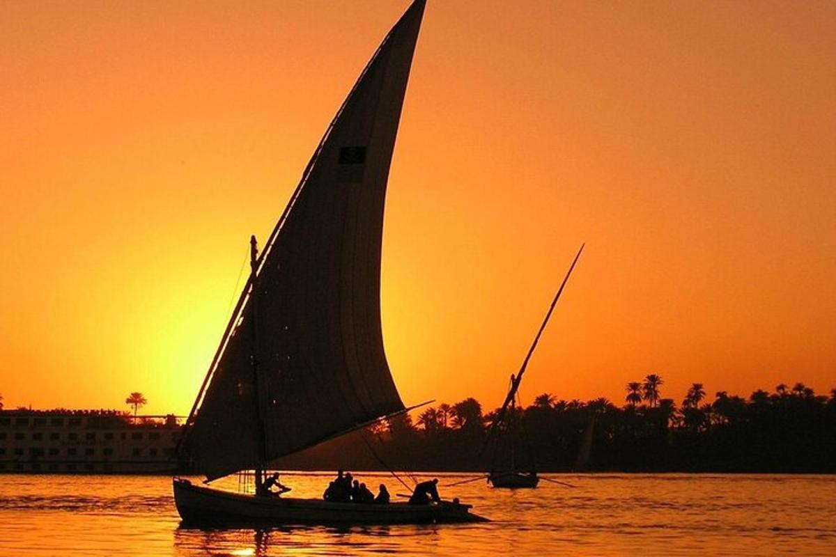 un gruppo di persone su una barca a vela in acqua al tramonto