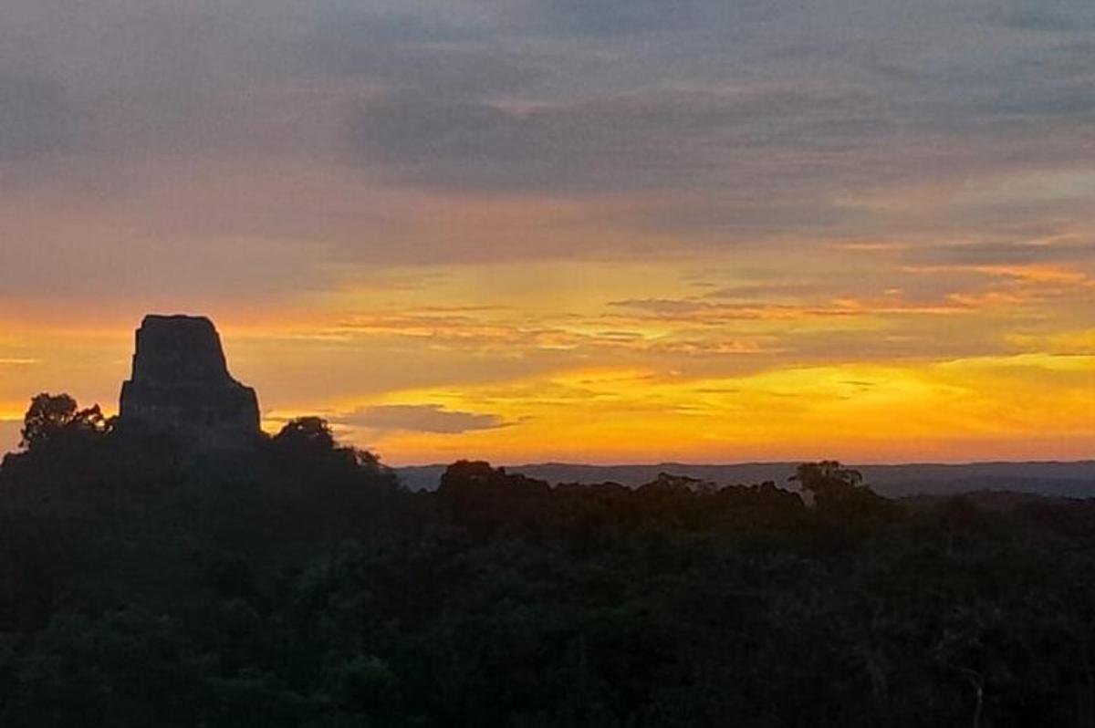 a sunset with a view of a rock formation