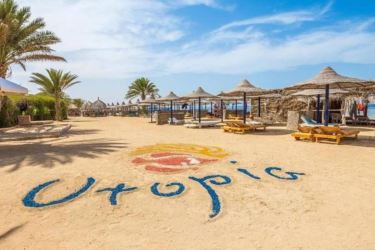 znak v pesku na plaži z dežniki