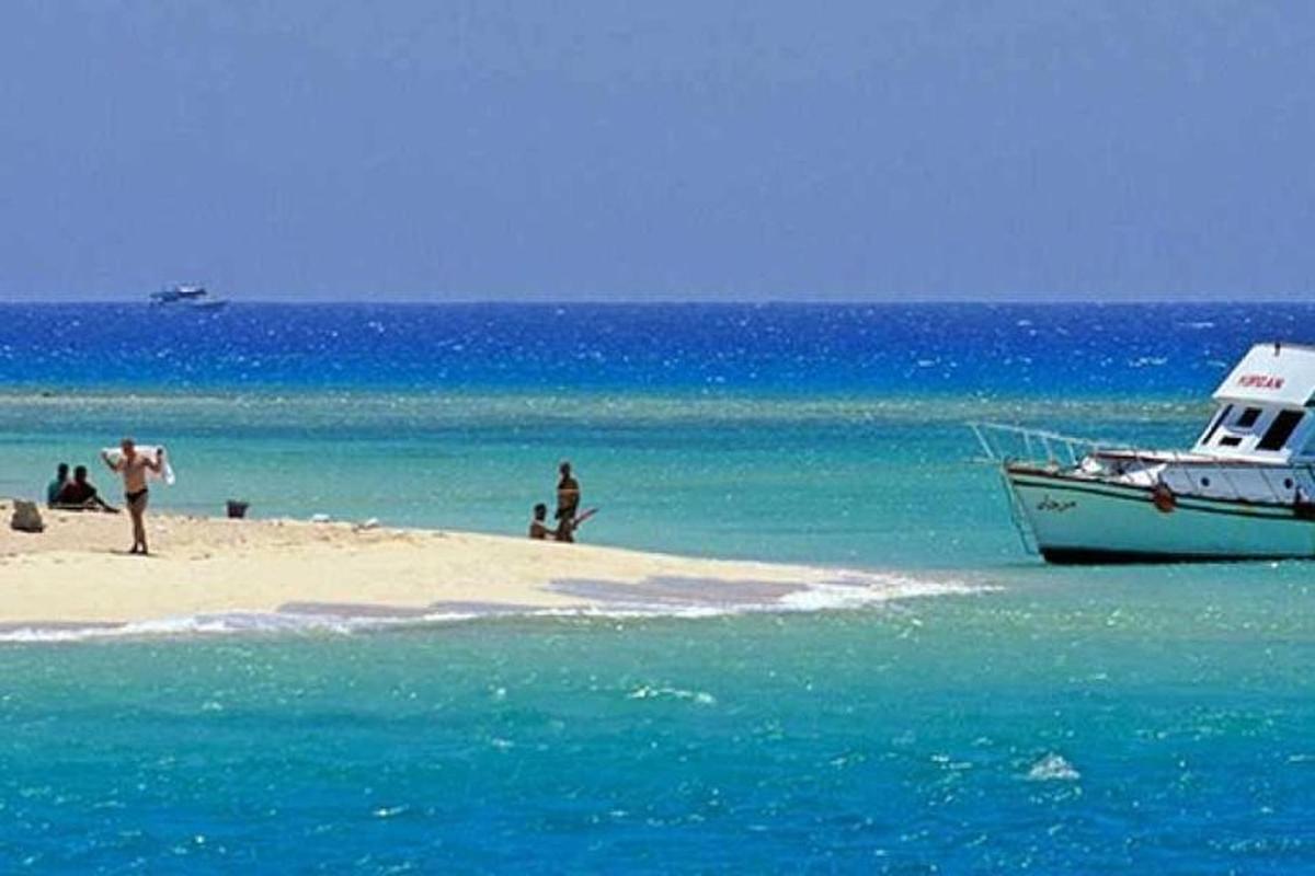 sebuah perahu yang terdampar di pantai dengan orang-orang di atasnya