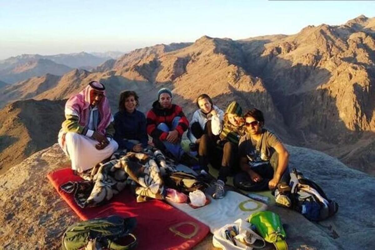 a group of people sitting on the top of a mountain