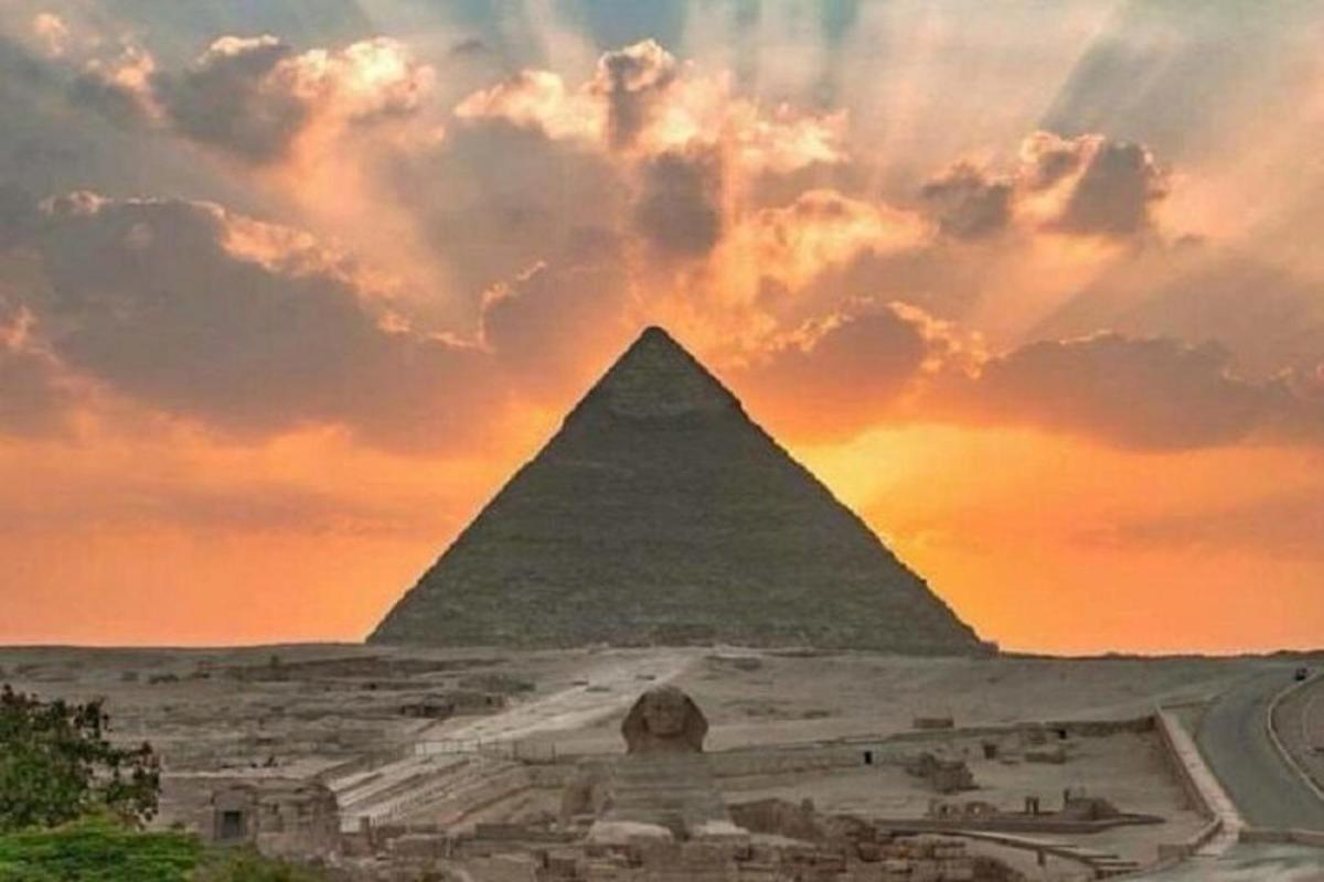 et maleri af pyramiderne ved solnedgang