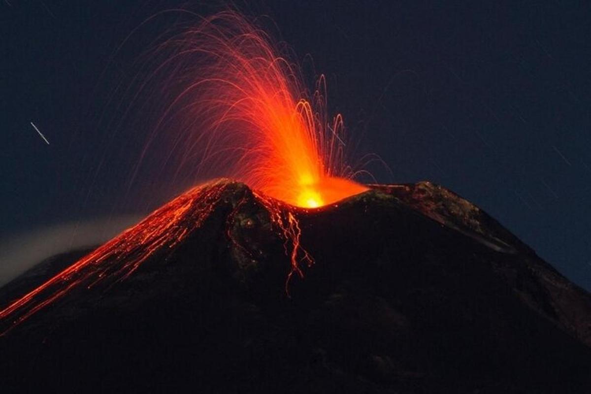 un vulcano in eruzione con lava in cima