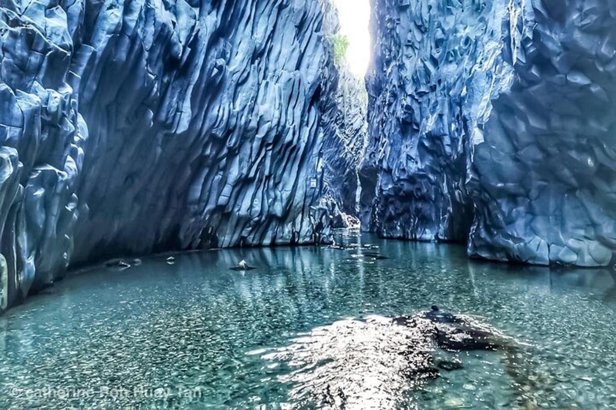 a blue ice cave with a body of water