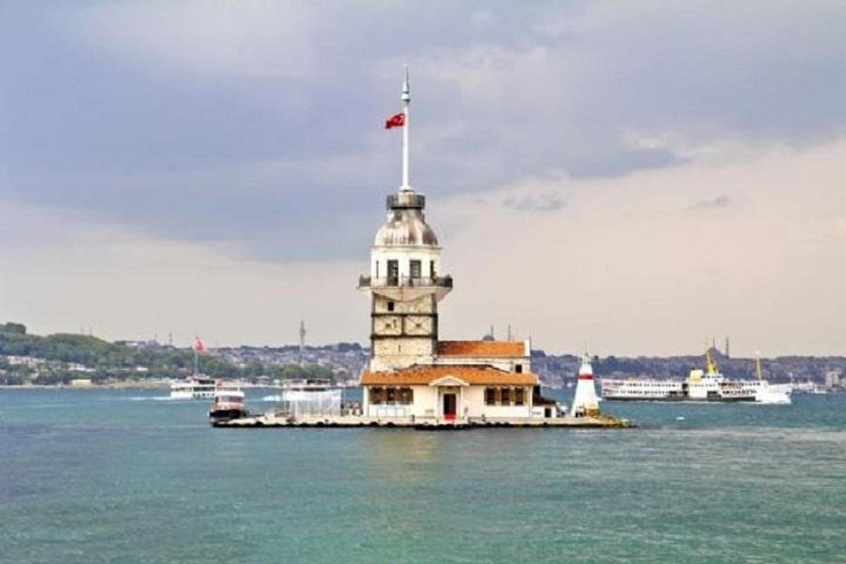 üstünde bayrak bulunan suda bir deniz feneri