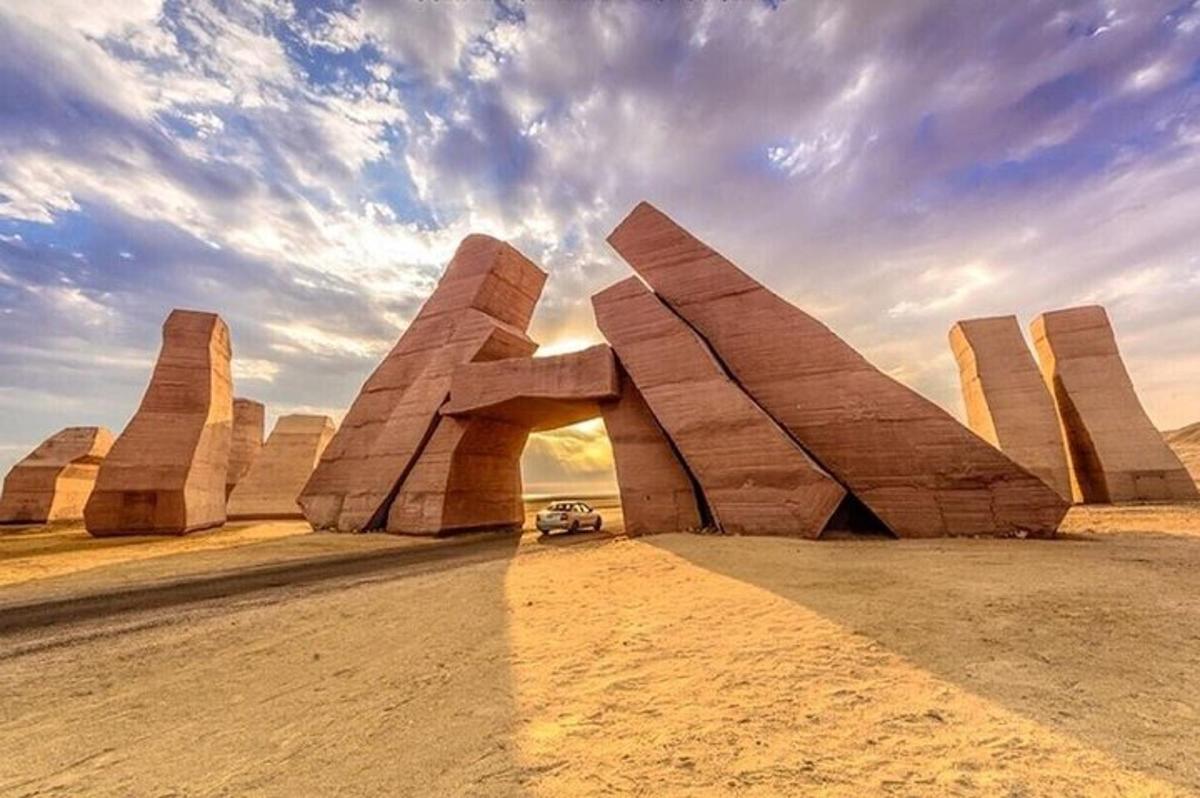 um carro passando por uma escultura no deserto
