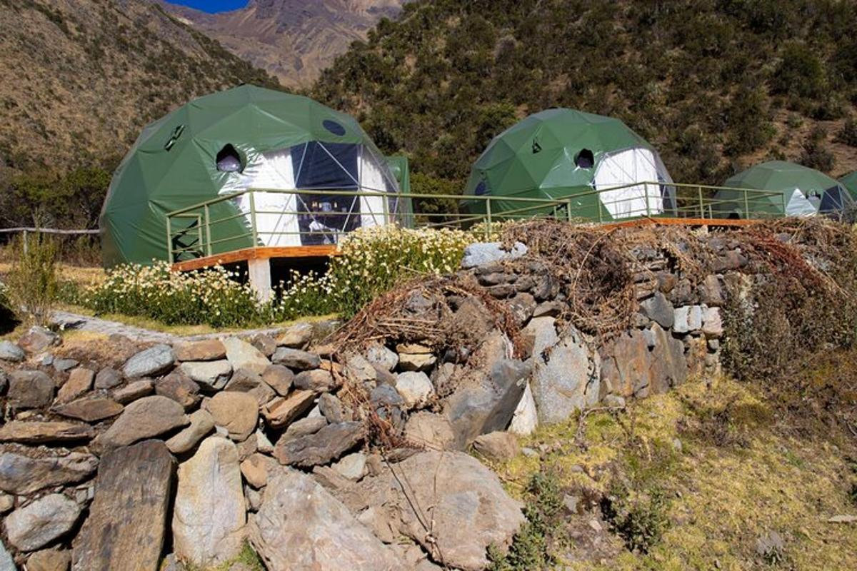 two green and white tents on top of a mountain