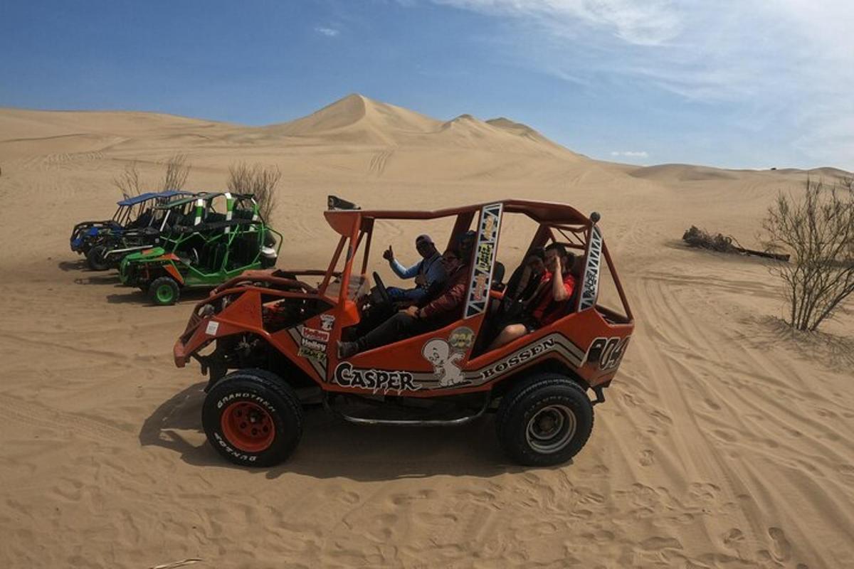 duas pessoas andando de quadriciclo no deserto