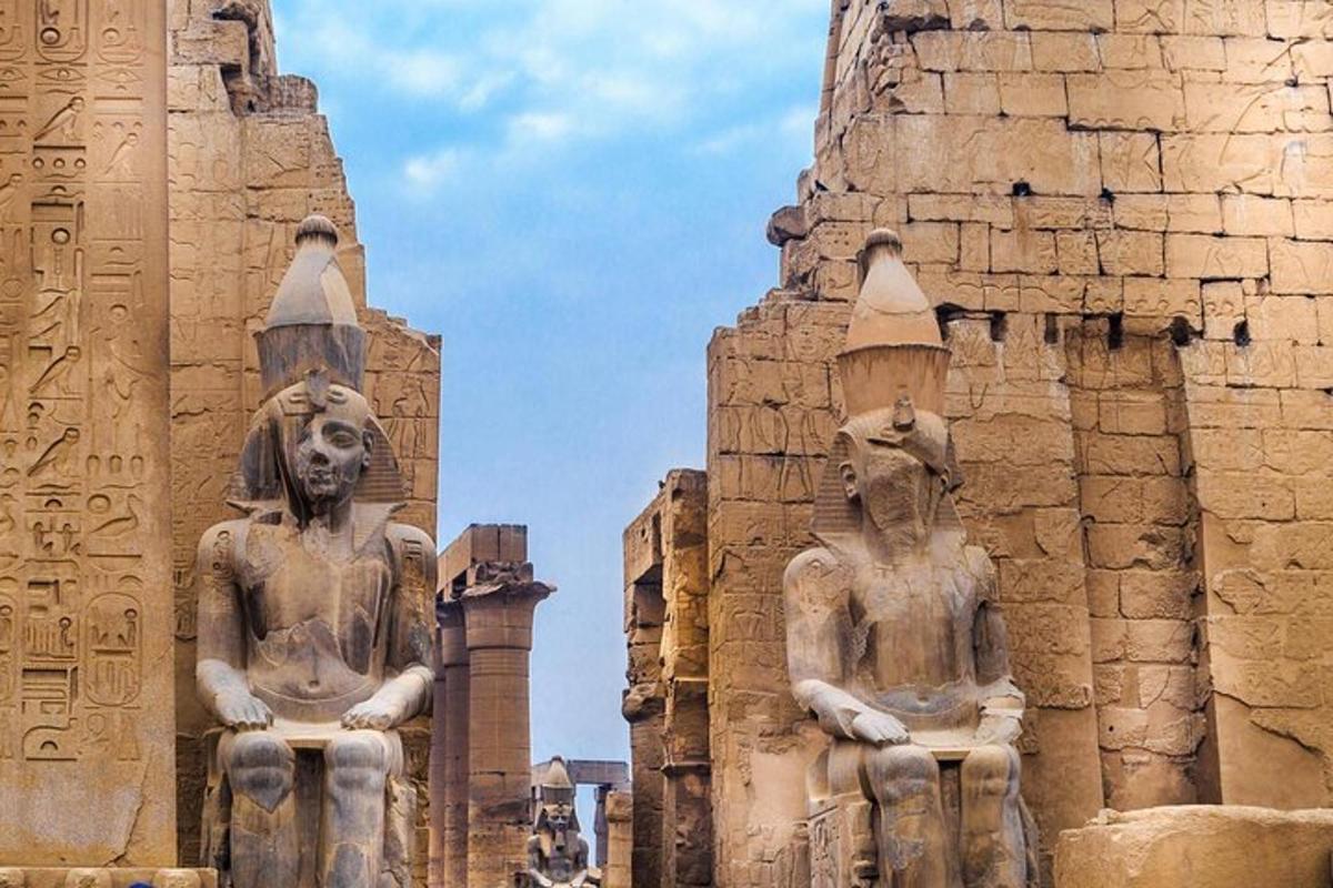 due statue di persone in piedi accanto a un edificio