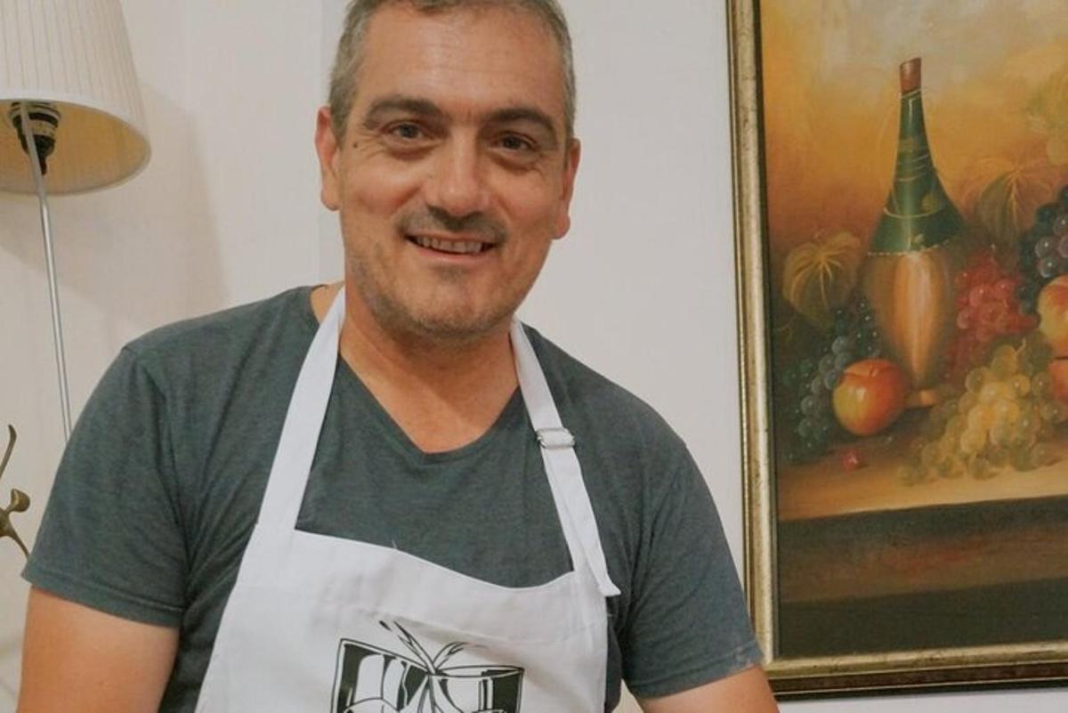 moški v belem predpasniku pred sliko