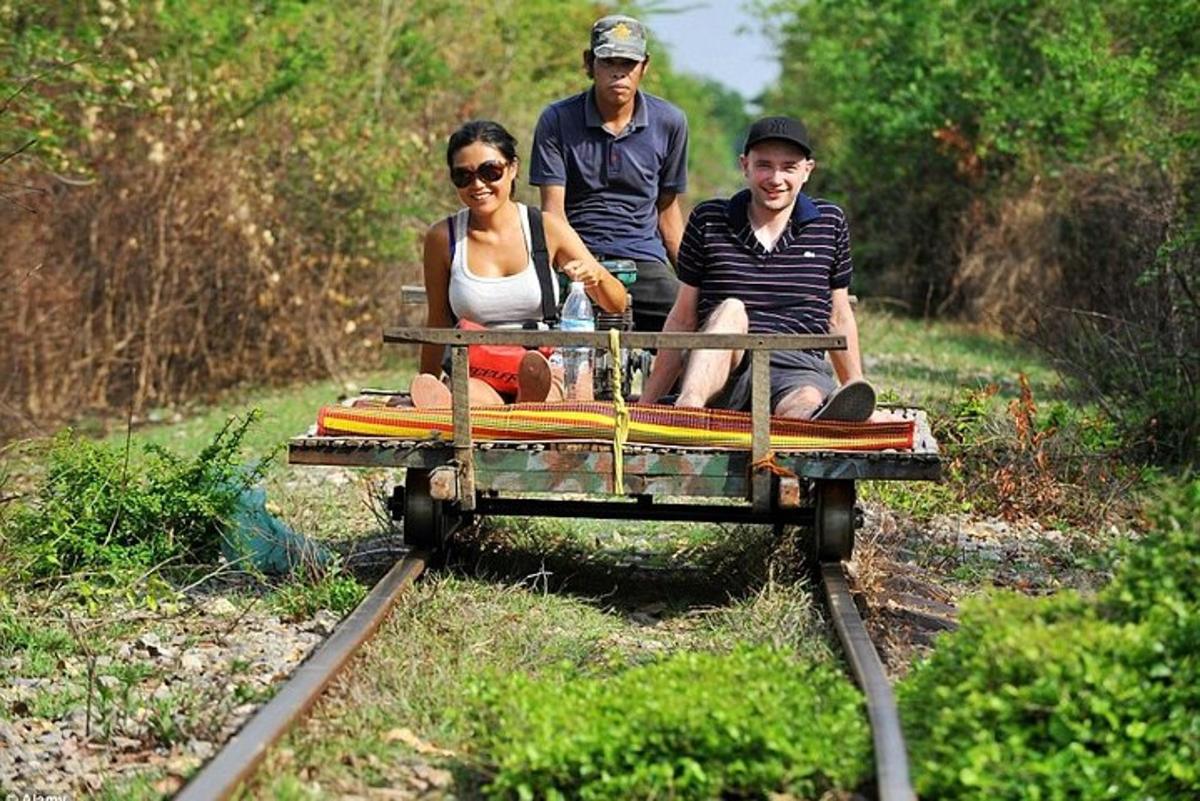 sekelompok tiga orang yang duduk di gerbong kereta