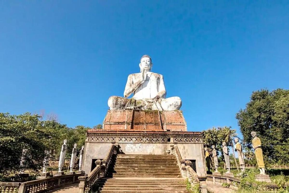 Una estatua de un hombre sentado en lo alto de unas escaleras.