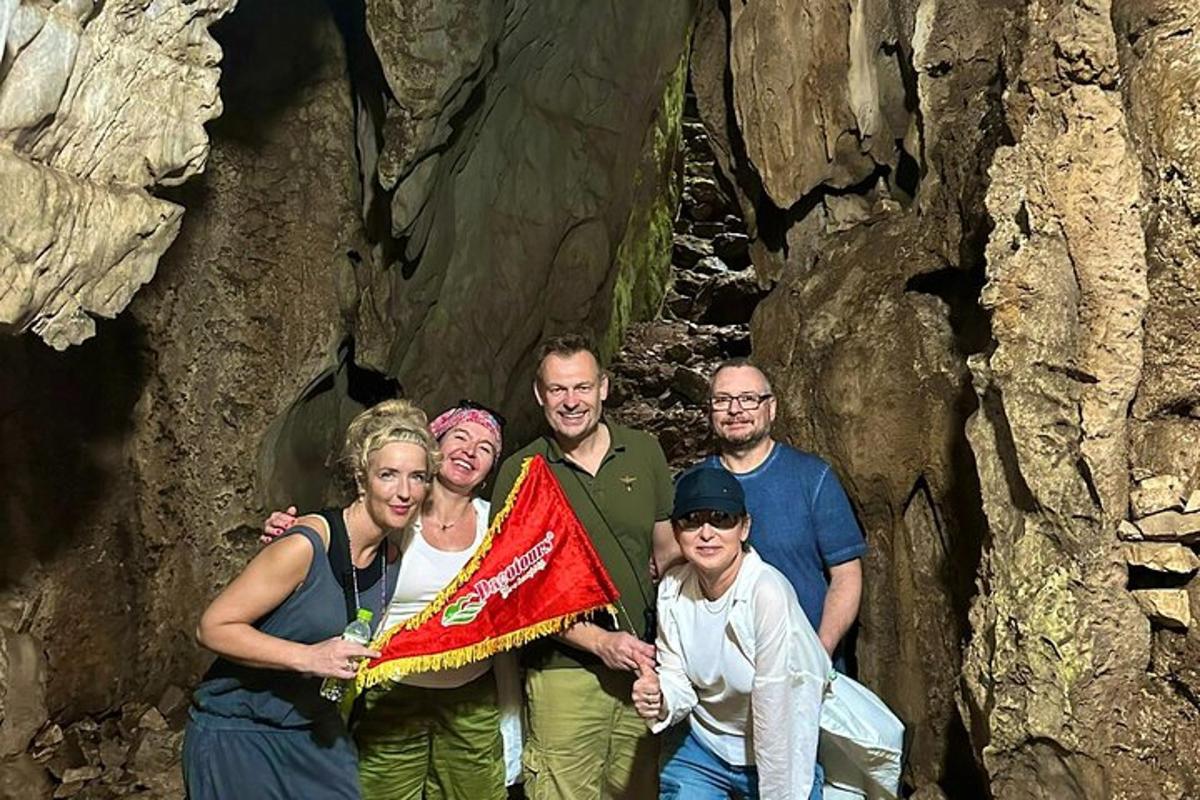 a group of people standing in a cave holding a kite