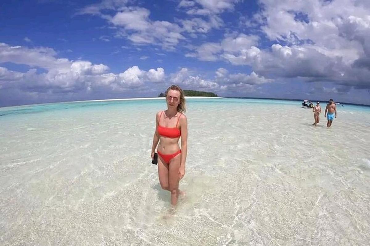 ženska v bikiniju, ki stoji v vodi na plaži