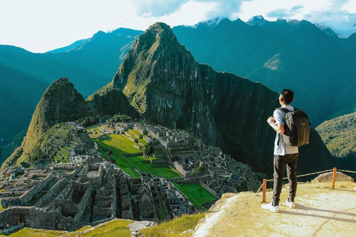 un homme debout au sommet d'une montagne regardant une ville
