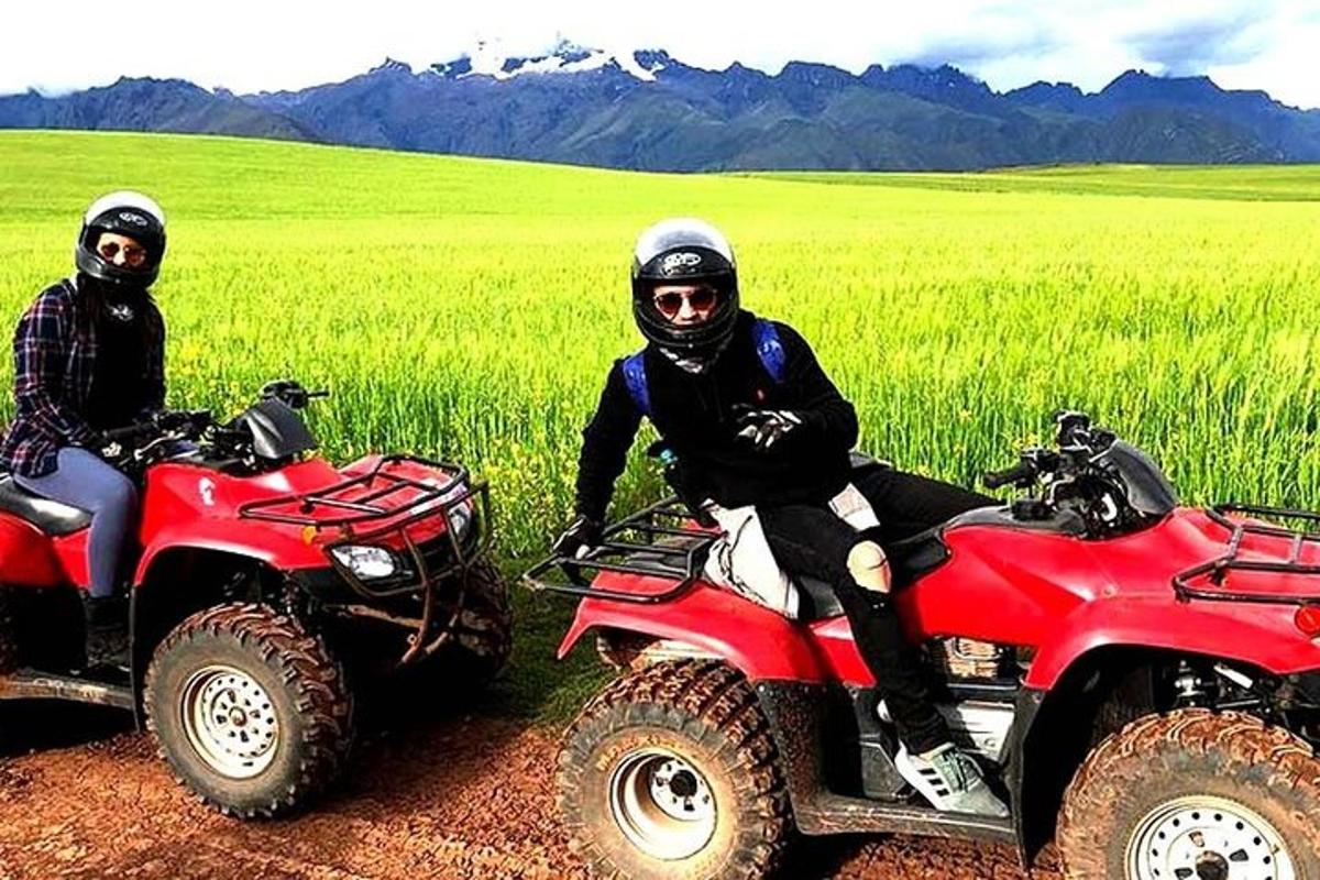 Dos hombres están sentados en vehículos todo terreno en un campo.