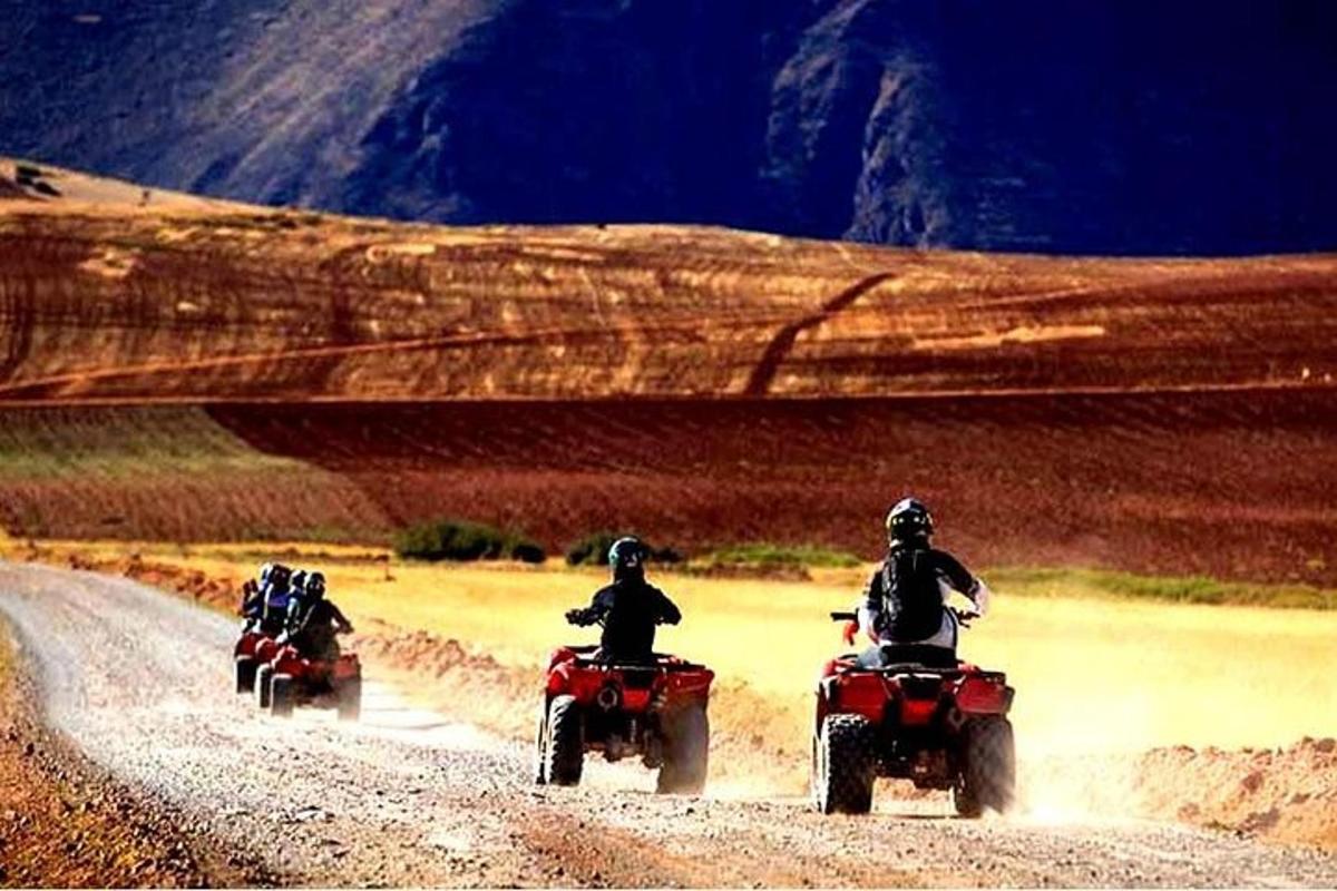 Tres personas viajando en motocicleta por un camino de tierra
