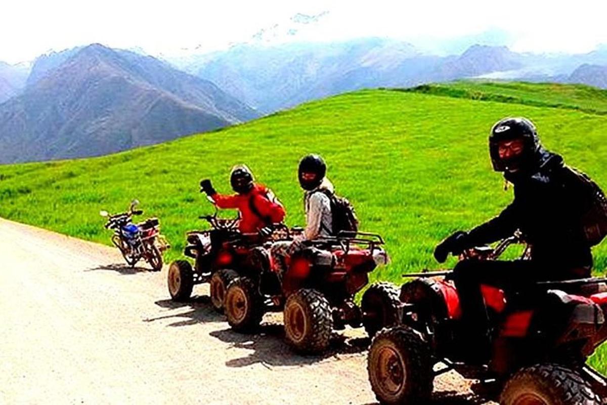 Un grupo de personas conduciendo vehículos todo terreno por una carretera de montaña.