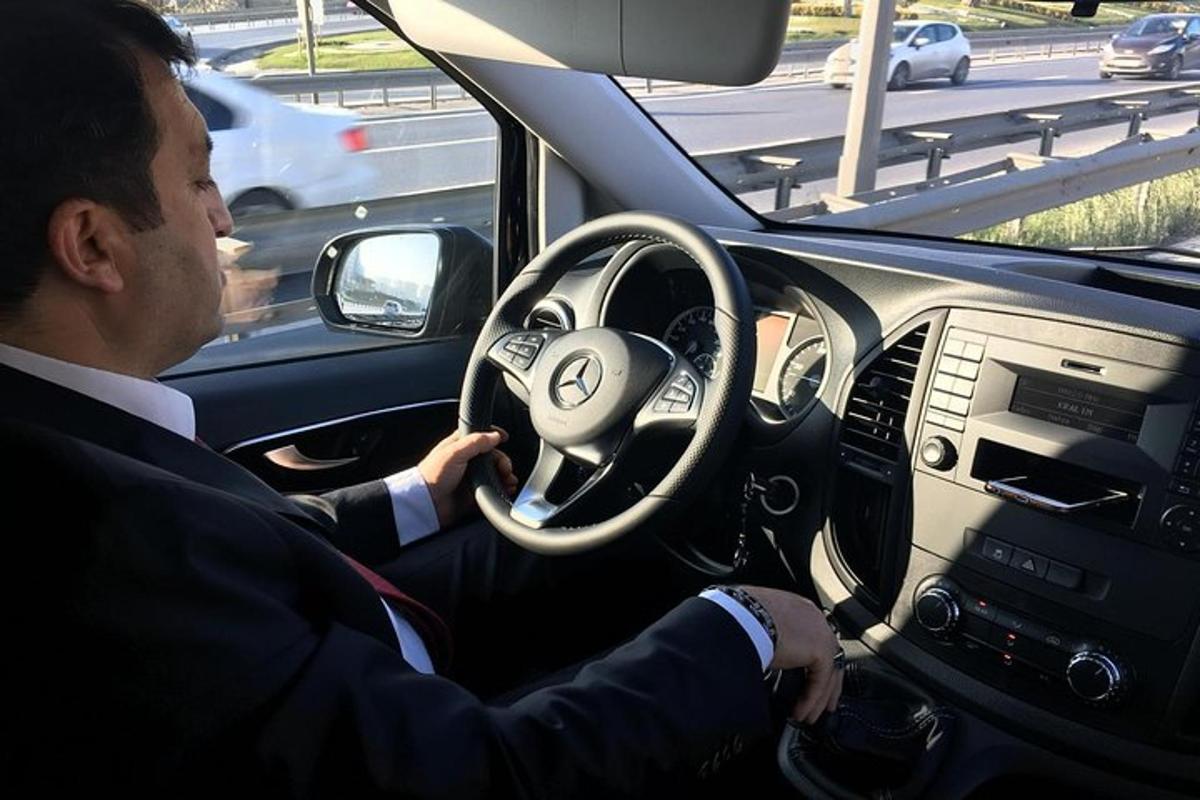 egy öltönyös férfi autót vezet