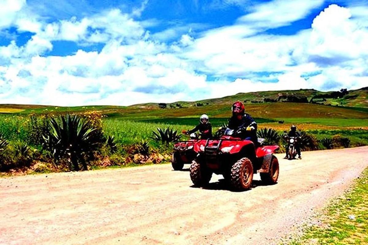 Dos personas viajando en vehículos todo terreno por un camino de tierra